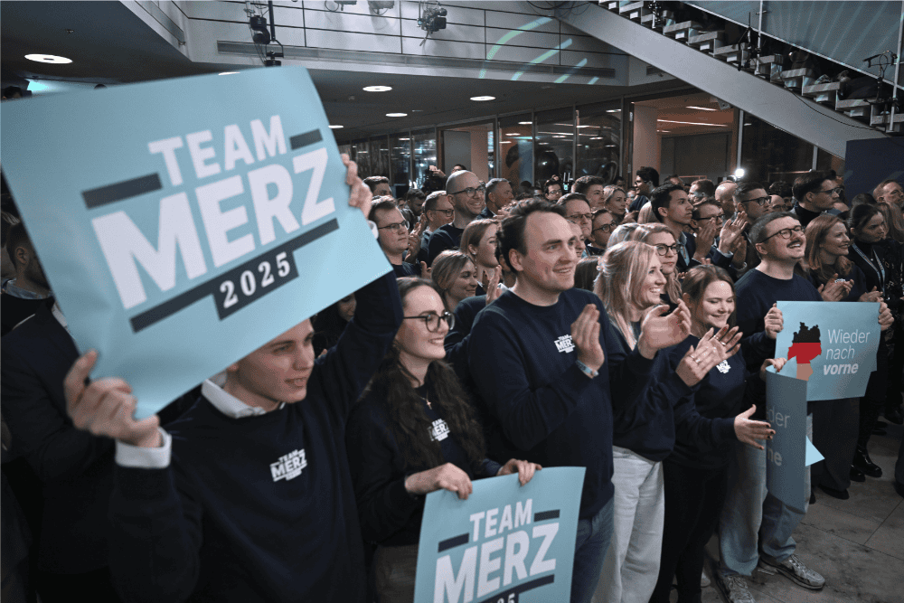 Friedrich Merz'in ekibi pankartlar ile Almanya'da seçim zaferini kutluyor.